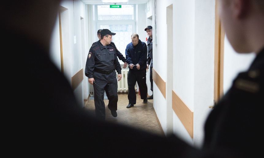 Конвой заводит в зал суда виновника ДТП Александра Городецкого: 42 года, среднее специальное образование, разведён, двое детей 16 и семи лет, официально не работает.